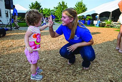 Young woman high-fives small child